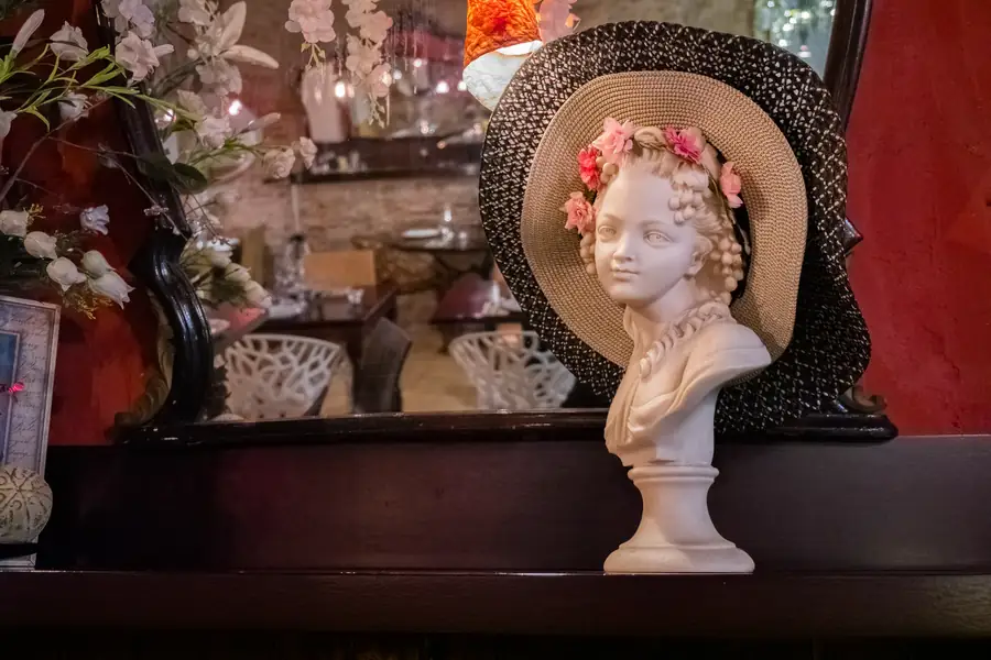 A corner of the dining room: antique mirrors, a marble bust, dried flowers.